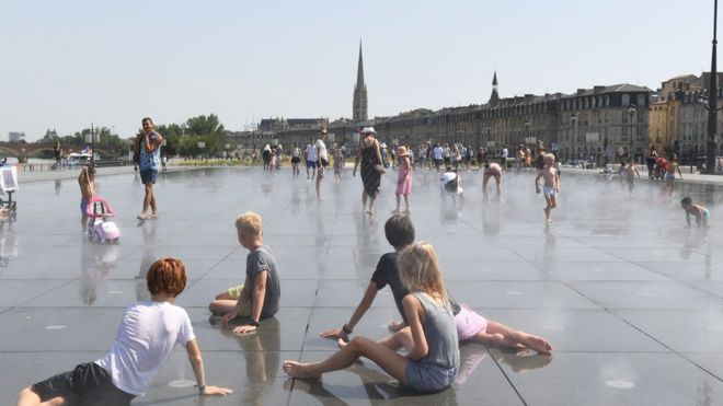 Children cool off at the Water Mirror on the Place de la Bourse as summer temperatures reach 42 degrees Celsius in the southwestern French city of Bordeaux