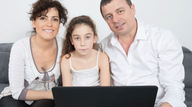 Семья сидит перед ноутбуком