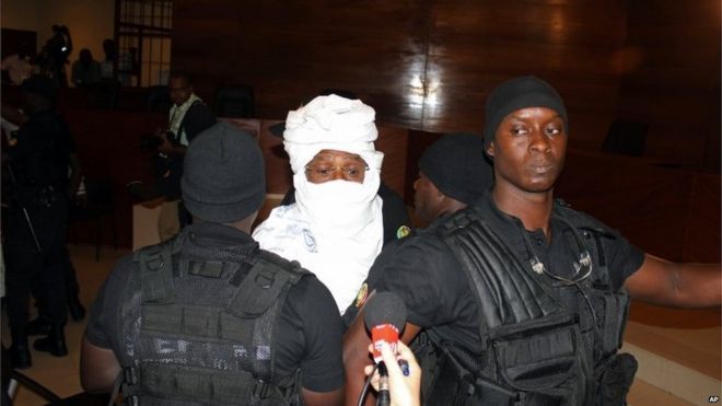 Сотрудники безопасности окружают бывшего чадского диктатора Хиссена Хабре в суде в Дакаре, Сенегал, понедельник, 20 июля 2015 г.