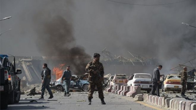 Афганский сотрудник сил безопасности стоит на месте взрыва автомобильной бомбы в Кабуле 31 мая 2017 года.
