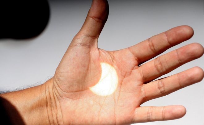 An image of the solar eclipse is projected onto a hand in Ensenada, Baja California, Mexico, 21 August 2017