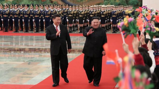 North Korean leader Kim Jong Un (R) and China"s President Xi Jinping waving to children