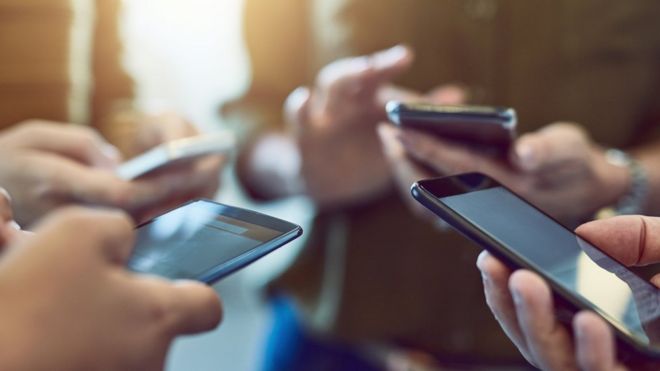 grupo de gente usando celulares