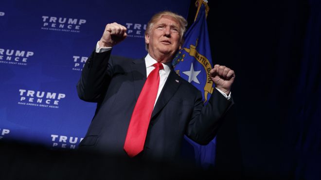 Кандидат в президенты от республиканцев Дональд Трамп выходит на сцену для предвыборного митинга в субботу, 5 ноября 2016 года, в Рино, штат Нью-Йорк.