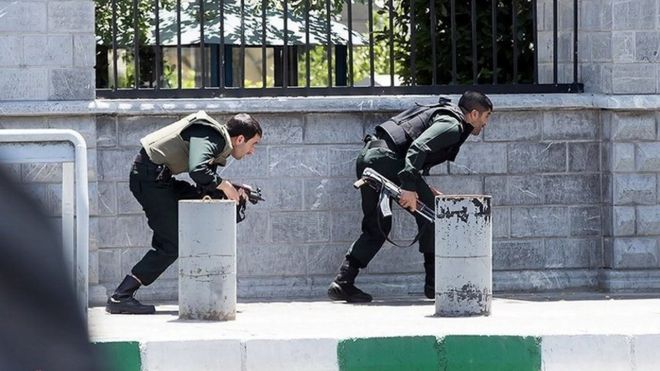 Members of Iranian forces take cover during an attack on the Iranian parliament in central Tehran, Iran, June 7, 2017
