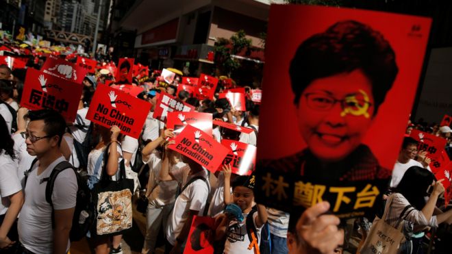 Demonstrators hold up a signs during a protest to demand authorities scrap a proposed extradition bill with China