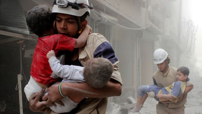 Members of the Civil Defence rescue children after what activists said was an air strike by government forces in the Shaar district of Aleppo (2 June 2014)