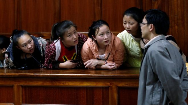 Граждане Тайваня и Китая арестованы по подозрению в мошенничестве с использованием телекоммуникаций, выслушают их переводчика, когда они сидят в судах Милимани, прежде чем их оправдают за киберпреступность в столице Кении Найроби (5 августа 2016 года)