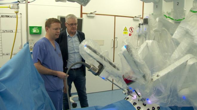 Консультант по урологии Хью О'Кейн и пациент Норман Адэйр на фото с роботом