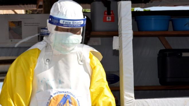 Человек в защитном снаряжении от лихорадки Эбола в лечебном центре в Бени
