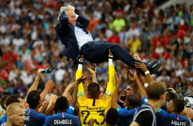 Тренер сборной Франции Дидье Дешам подбрасывает в воздух своих игроков, когда они празднуют победу на Кубке мира 15 июля 2018 года