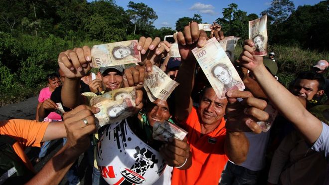 Gente con billetes de 100 bolívares