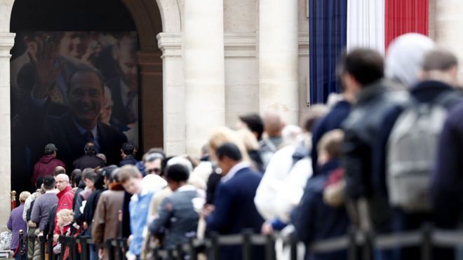 Visitors wait to view the coffin of former French President Jacques Chirac as it lies in state in the Invalides 29 September 2019.