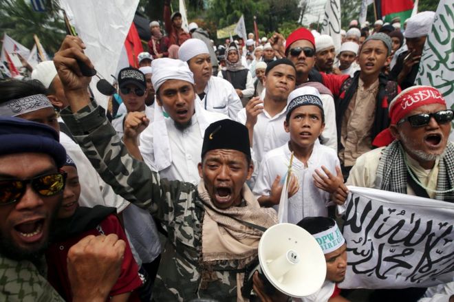 Индонезийские мусульманские протестующие реагируют на то, что губернатор Джакарты Басуки Тяхаджа Пурнама был приговорен к двум годам тюремного заключения за богохульство у здания окружного суда Северной Джакарты в Джакарте, Индонезия, 9 мая 2017 года.