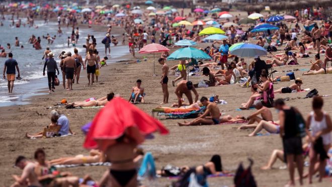 People on a sunny day at the beach in Malaga in June