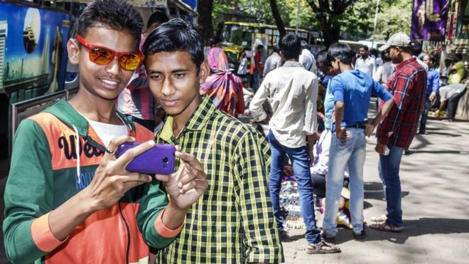 Индия Мумбаи Форт Мумбаи Кала Года Махатма Ганди-роуд подросток мальчик мужчина друзья глядя смартфон.