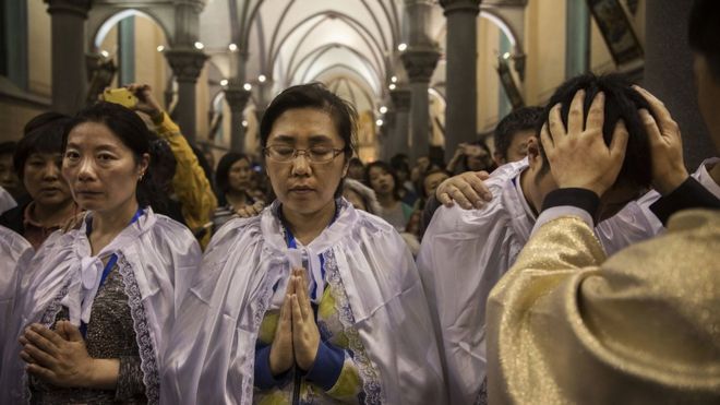 Chinese Catholic Bishop Zhang Hong, right, blesses newly baptized worshippers during a special ceremony at a mass on Holy Saturday during Easter celebrations at the government sanctioned West Beijing Catholic Church on April 15, 2017 in Beijing, China. China, an officially atheist country, places a number of restrictions on Christians, allowing legal practice of the faith only at state-approved churches.