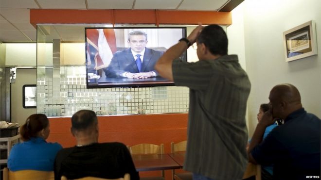 Люди сидят в ресторане, слушая выступление губернатора Алехандро Гарсиа Падиллы во время телевизионной речи в Сан-Хуане, Пуэрто-Рико, 29 июня 2015 года.
