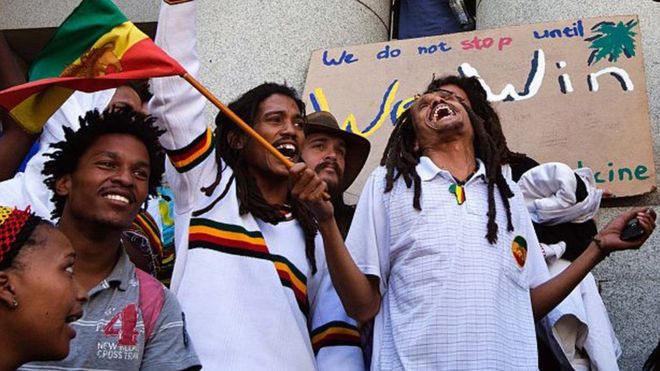 Око 100 растафаријанаца и других активиста певају и играју испред Вишег суда у Кејптауну у знак подршке судској пријави због декриминализације даге (марихуане / канабиса) 7. децембра 2015. године у центру града