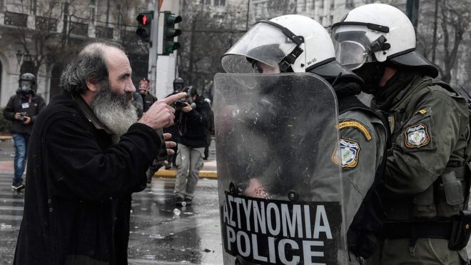 Священник спорит с полицией по охране общественного порядка во время демонстрации против соглашения со Скопье о переименовании соседней страны Македония в Республику Северная Македония, 20 января 2019 года в Афинах