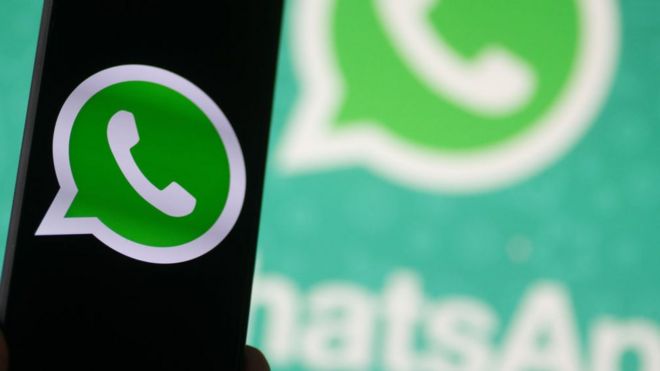 Logo de WhatsApp en un teléfono con pantalla oscura