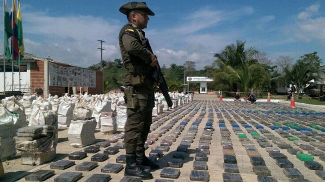Colombian police officer guards confiscated packages of cocaine in Turbo, Colombia, 15 May 2016