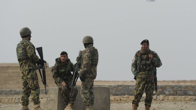 Afghan National Army (ANA) soldiers (troops) standing guard, as a US helicopter flies past, outside Bagram military base, some 50 kms north of Kabul on January 23rd 2014.