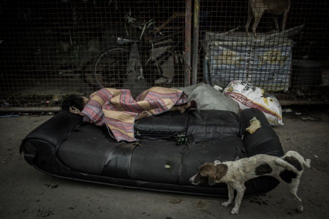Девушка спит на обочине улицы в районе Парола Тондо, Манила-Сити