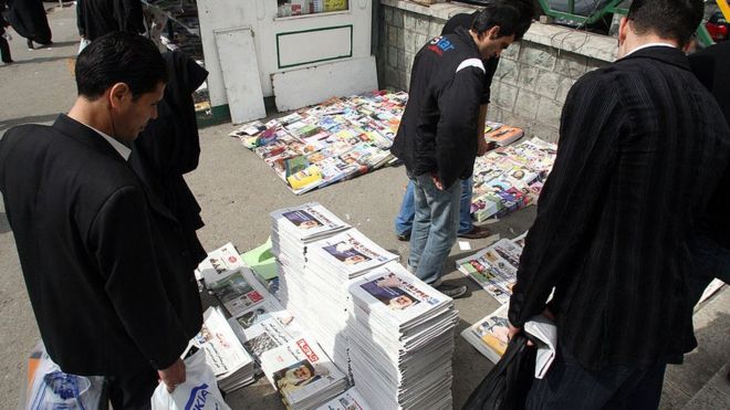 Иранские мужчины смотрят на стопки газет в Тегеране (файл)