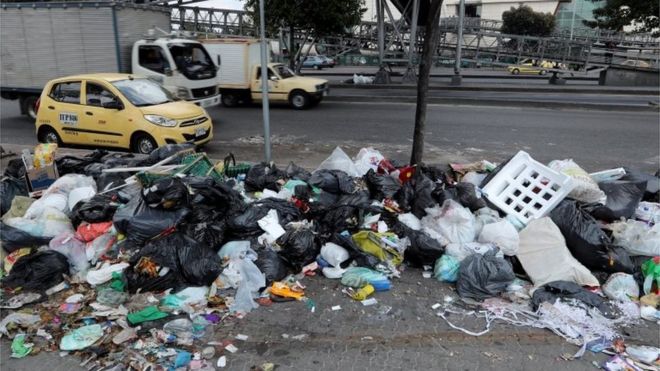 Автомобили едут на мусорных мешках, оставленных на тротуаре в Боготе, Колумбия, 07 февраля 2018 года