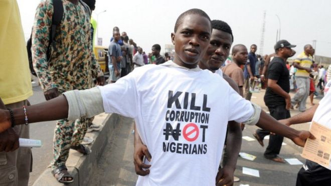 Протестующий носит антикоррупционную футболку 9 января 2012 года в Лагосе во время демонстрации против более чем удвоения цен на бензин после отмены правительством субсидий на топливо.