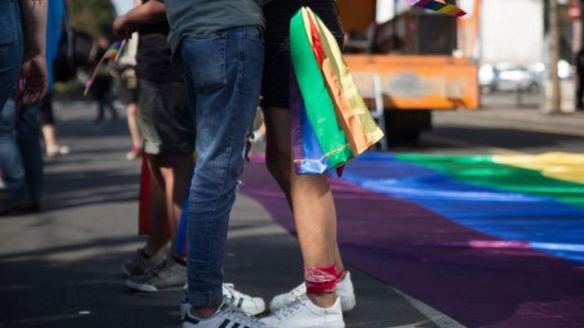 Par se grli, devojka nosi LGBT zastavu