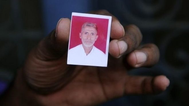 Родственник держит фотографию убитого индийского жителя деревни Мохаммада Ахлака в своем доме в деревне Бисада,