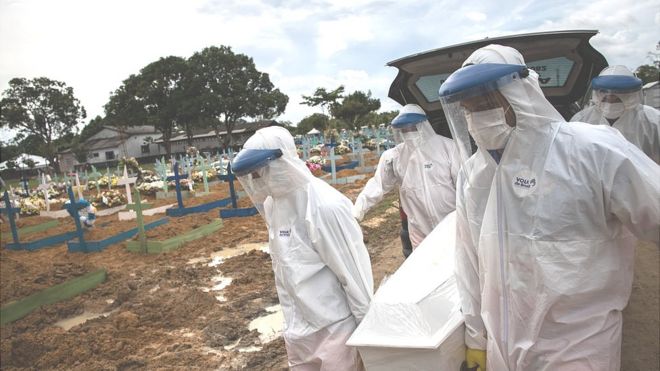 Coveiros com roupas de proteção carregam caixão de vítima da covid-19 no cemitério Nossa Senhora Aparecida, em Manaus, Amazonas