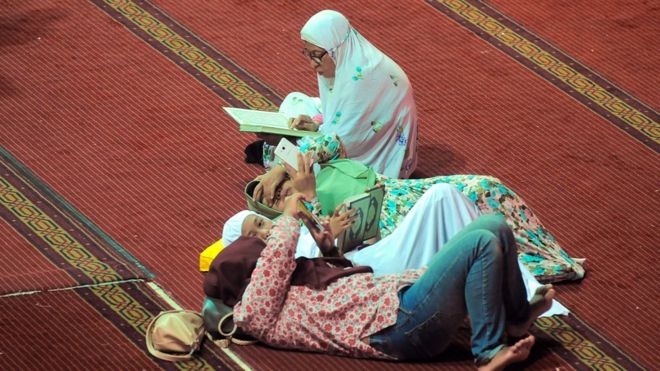 امرأة تقرأ القرآن في مسجد في جاكرتا