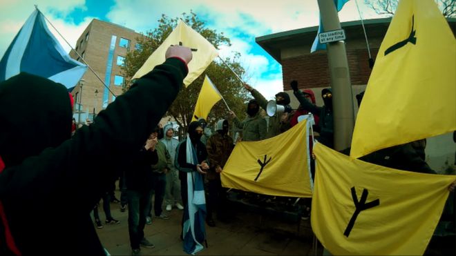 National Action alias group Scottish Dawn demonstrating. some are carrying yellow flags with the Scottish Dawn symbol which strangely resembles a chicken's footprint