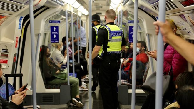 Полицейские проверяют пассажиров на предмет масок в Лондоне, Великобритания