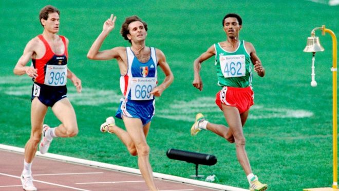 Pascal Thiebaut of France (C), surrounded by Abel Anton Rodrigo of Spain (L) and Fita Bayisa of Ethiopia (R), waves after winning the Men's 5000m semi- final athletics event of the Barcelona Olympic Games, on August 6, 1992 in Barcelona.