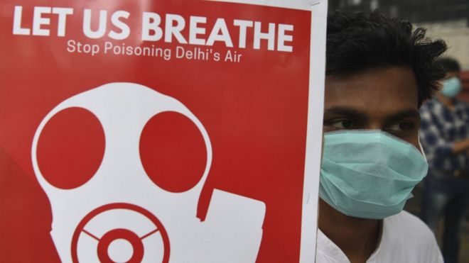 A demonstrators wearing a face mask due to heavy smog conditions takes part in a demonstration on 3 Nov