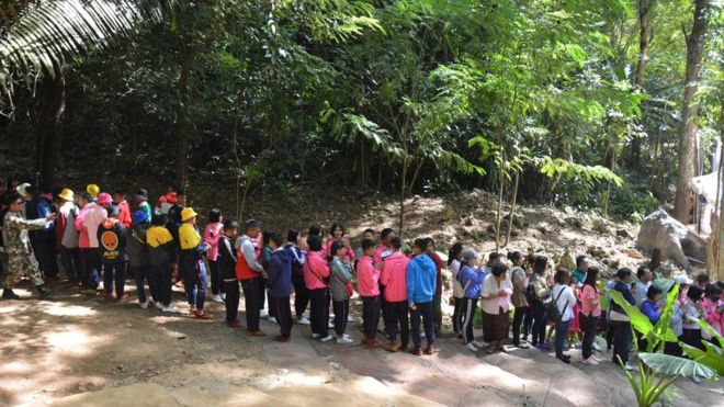 На раздаточной фотографии, предоставленной Управлением по связям с общественностью провинции Чианграй, показаны люди, стоящие в очереди, чтобы войти в пещеру Тхам Луанг в районе Мае Сай, провинция Чианграй, Таиланд, 1 ноября 2019 года.