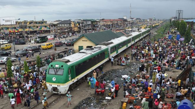 Поезд канцелярских товаров в Нигерии в окружении толпы людей