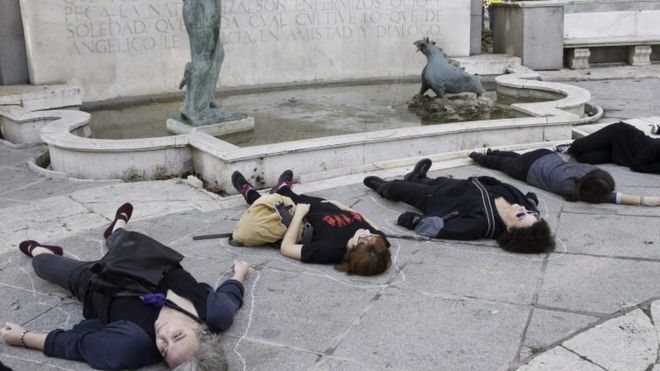 Женщины лежат на земле, притворяясь мертвыми во время марша в Мадриде. Фото: 7 ноября 2015 г.