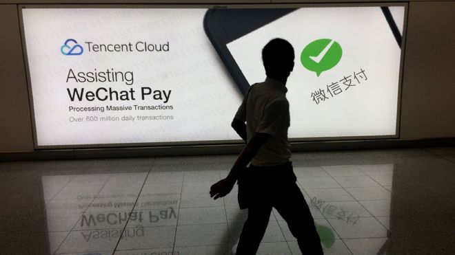 Человек проходит мимо объявления WeChat