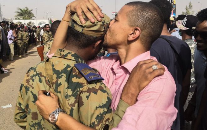 Muandamanaji anayepinga utawala wa Sudan akimbusu askari kichwani wakati wa maandamano mjini Khartoum , Sudan - Alhamisi tarehe 11 Aprili 2019