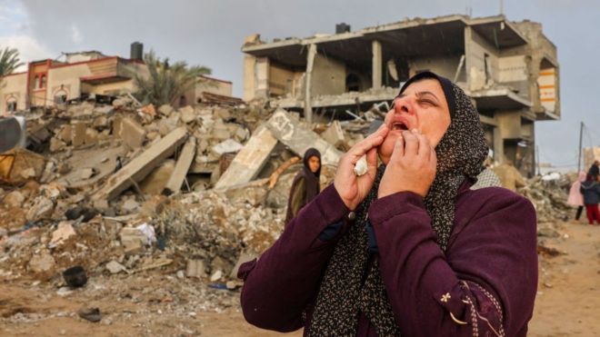 A Palestinian woman reacts as people inspect the damage after Israeli strikes on Rafah, on the southern Gaza Strip, in November 2023