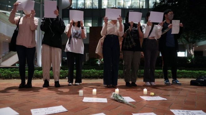 11月29日，在香港的大陆学生在香港大学为中国新冠“清零”政策受害者和乌鲁木齐大火的受害者守夜时高举着白纸。