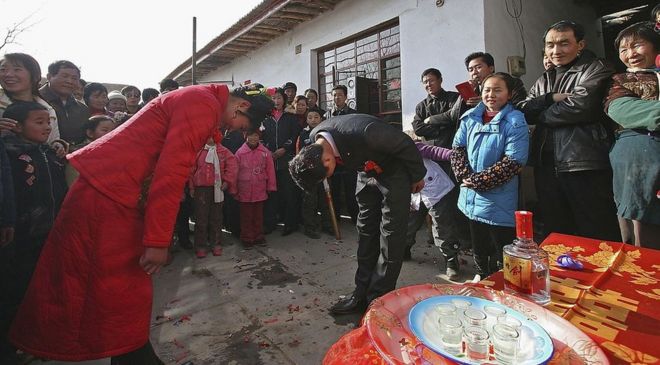 Жених и невеста из Китая кланяются друг другу во время свадебной церемонии 19 января 2006 года в уезде Линьцзэ провинции Ганьсу на северо-западе Китая
