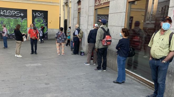 Una cola de personas esperando a recibir alimentos en Madrid