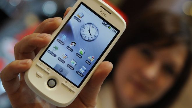 A woman holding an HTC phone