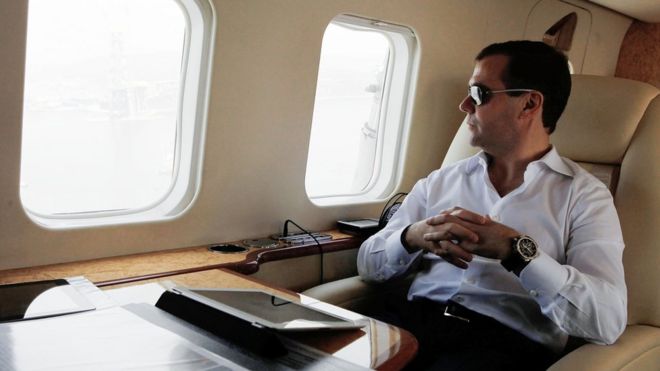 Дмитрий Медведев смотрит в окно вертолета с iPad на столе перед собой